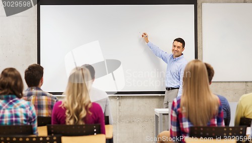 Image of group of students and smiling teacher in classroom