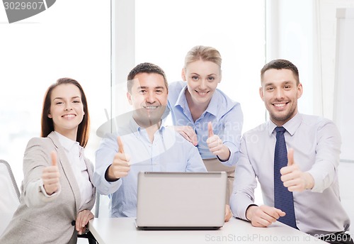 Image of business team working with laptop in office