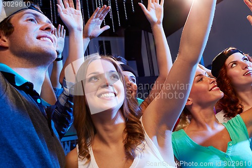 Image of smiling friends at concert in club