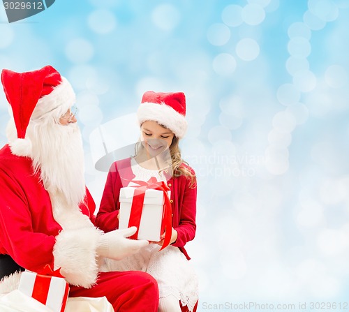 Image of smiling little girl with santa claus and gifts