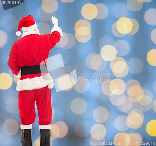Image of man in costume of santa claus writing something