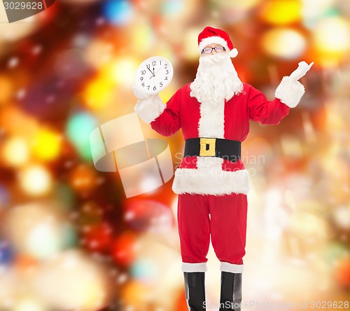 Image of man in costume of santa claus with clock