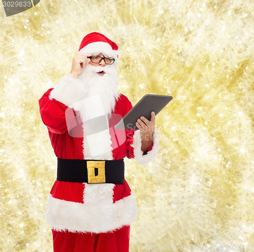 Image of man in costume of santa claus with tablet pc