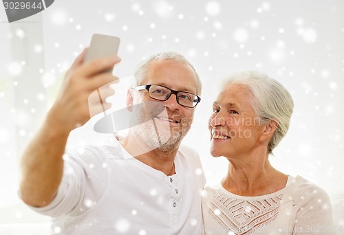 Image of happy senior couple with smartphone at home