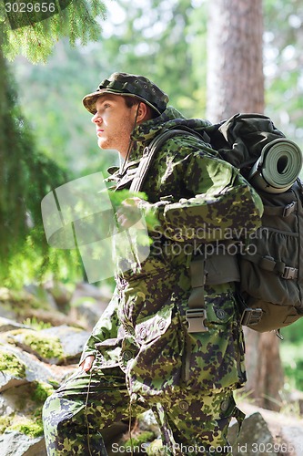 Image of young soldier with backpack in forest