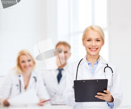 Image of smiling female doctor with clipboard