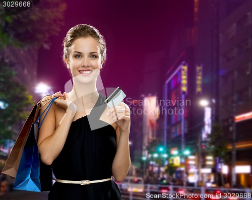 Image of smiling woman with shopping bags and credit card