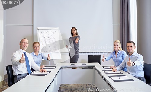 Image of group of smiling businesspeople showing thumbs up