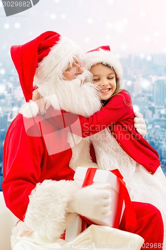 Image of smiling little girl with santa claus and gifts