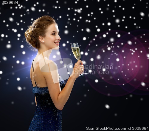 Image of smiling woman holding glass of sparkling wine