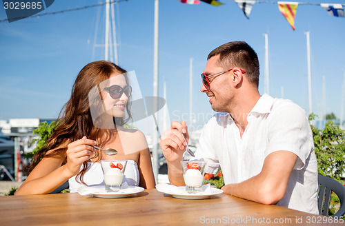 Image of smiling couple eating dessert at cafe