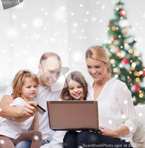 Image of happy family with laptop and credit card at home