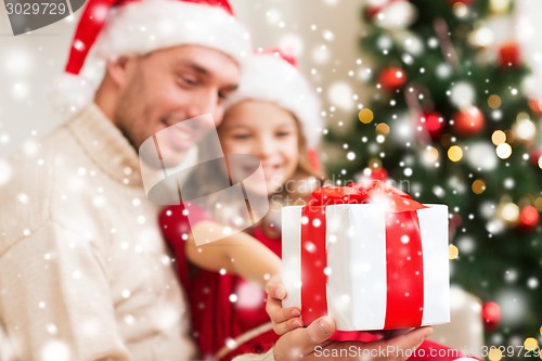 Image of smiling father and daughter holding gift box