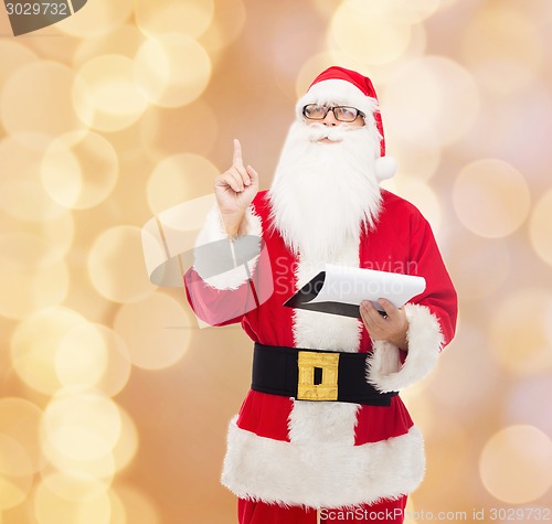 Image of man in costume of santa claus with notepad