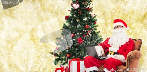 Image of man in costume of santa claus with laptop