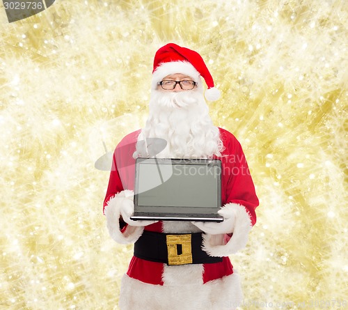 Image of man in costume of santa claus with laptop