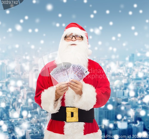 Image of man in costume of santa claus with euro money