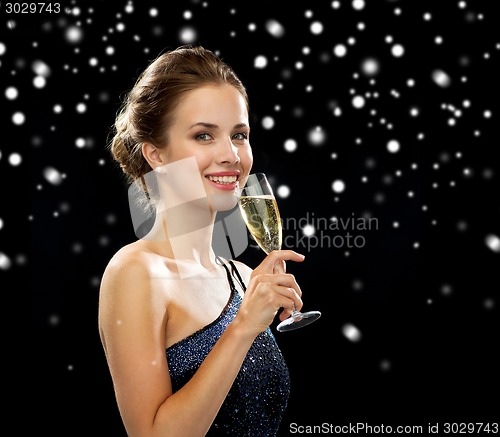 Image of smiling woman holding glass of sparkling wine