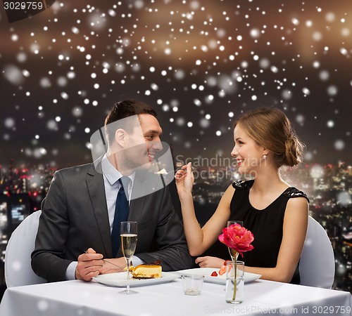 Image of smiling couple eating dessert at restaurant