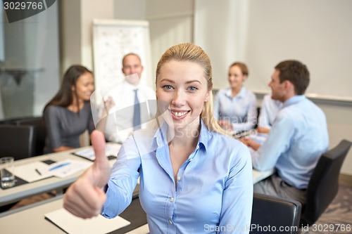 Image of group of smiling businesspeople meeting in office