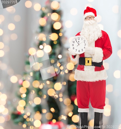 Image of man in costume of santa claus with clock