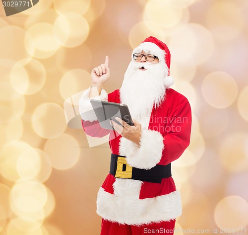 Image of man in costume of santa claus with tablet pc