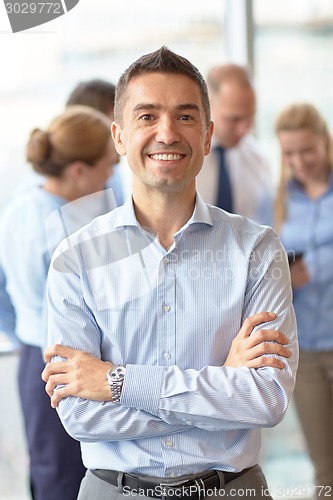 Image of group of smiling businesspeople meeting in office
