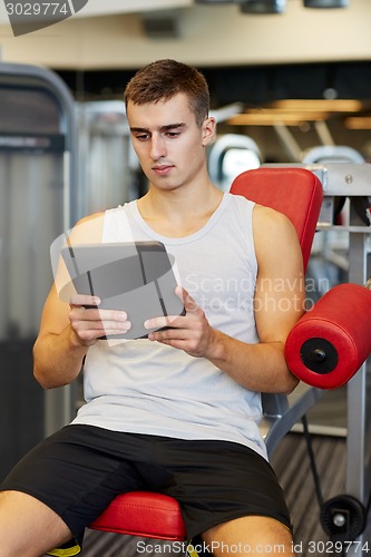 Image of young man with tablet pc computer in gym