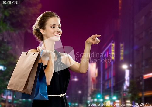 Image of smiling woman in evening dress with shopping bags