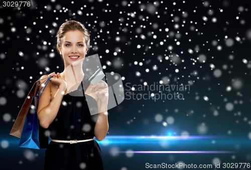 Image of smiling woman with shopping bags and credit card