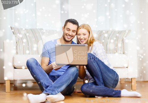 Image of smiling happy couple with laptop at home