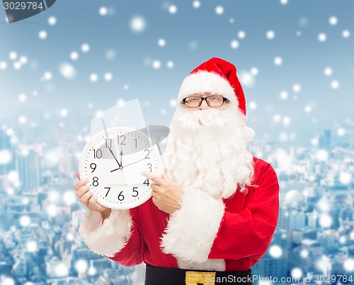 Image of man in costume of santa claus with clock