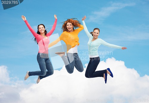 Image of group of smiling young women jumping in air