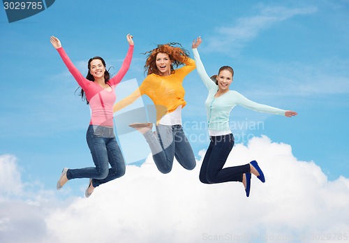 Image of group of smiling young women jumping in air