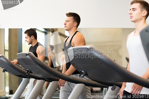 Image of group of men exercising on treadmill in gym