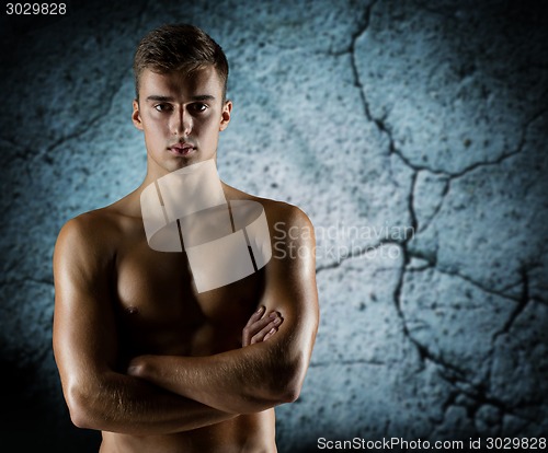 Image of young male bodybuilder with bare muscular torso