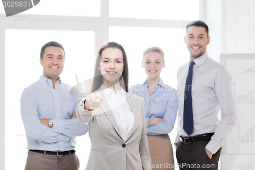 Image of businesswoman in office pointing finger at you