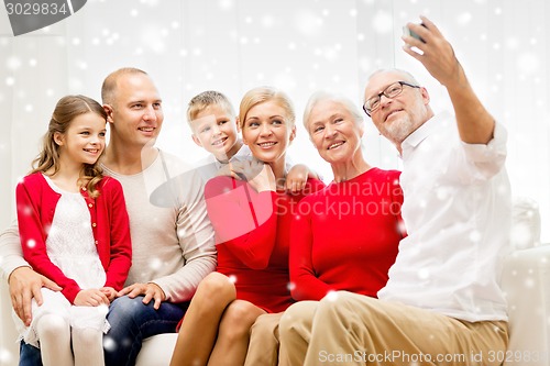 Image of smiling family with camera at home