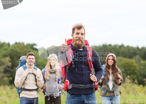 Image of group of smiling friends with backpacks hiking