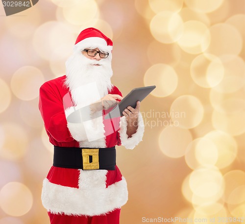 Image of man in costume of santa claus with tablet pc