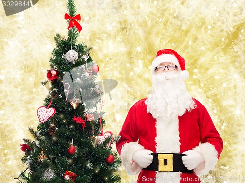 Image of man in costume of santa claus with christmas tree