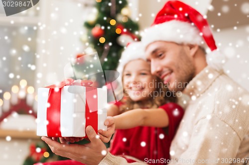 Image of smiling father and daughter holding gift box