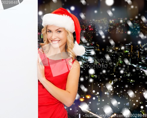 Image of smiling young woman in santa hat with white board