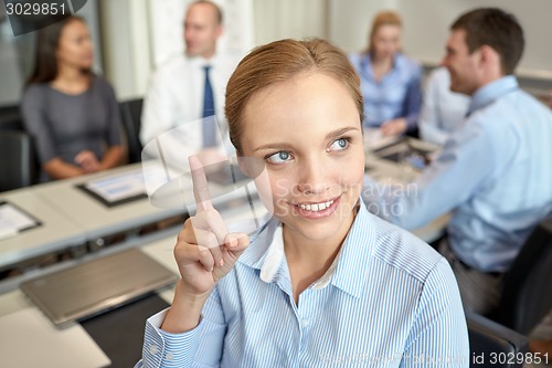 Image of group of smiling businesspeople meeting in office
