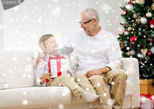 Image of smiling grandfather and grandson at home