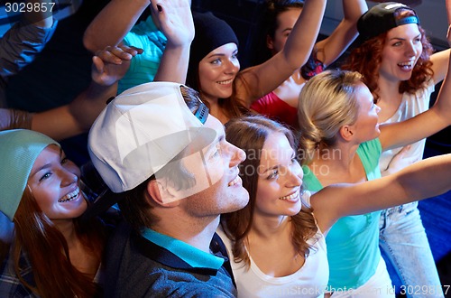 Image of smiling friends at concert in club