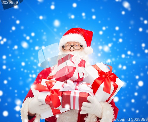 Image of man in costume of santa claus with gift boxes