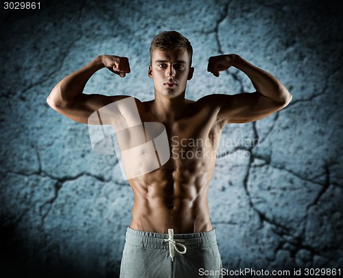 Image of young man showing biceps and muscles