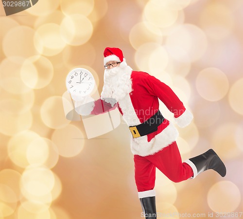 Image of man in costume of santa claus with clock