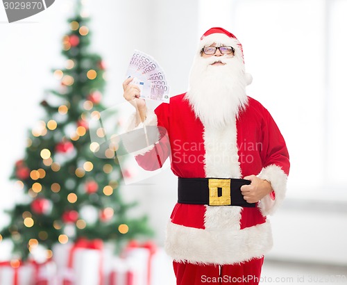 Image of man in costume of santa claus with euro money